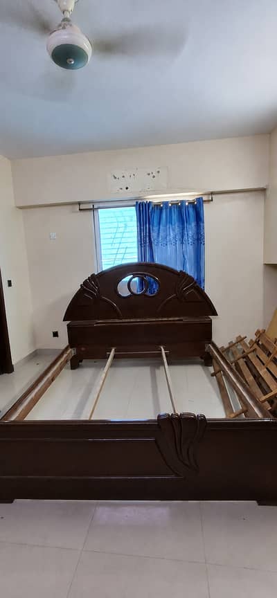 Wooden double bed, with two side tables.