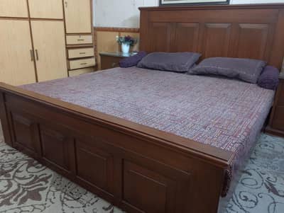 A king size bed in a very good condition with 2 side tables and a styl