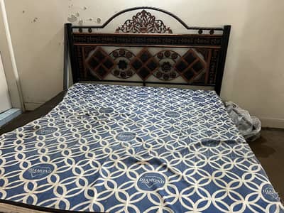 iron bed with mattress and dining table