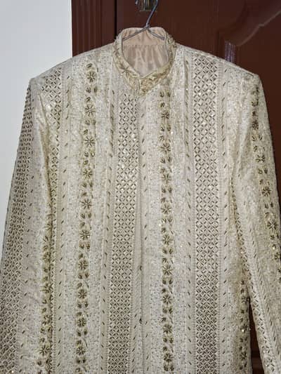 Off white embroidered sherwani with silk kurta pajama and red kulla