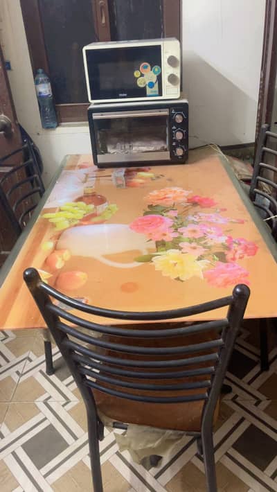 Dinning table with four cushion chairs .