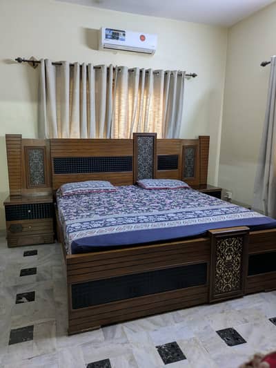 King size bed brown color with black metallic design and side tables.