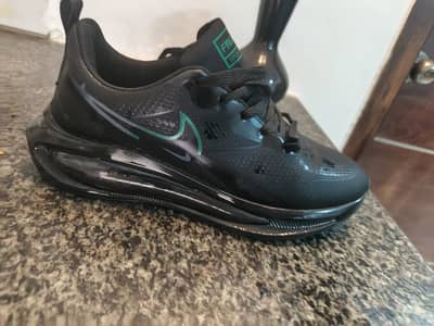A sleek pair of Nike black sneakers, size 43.