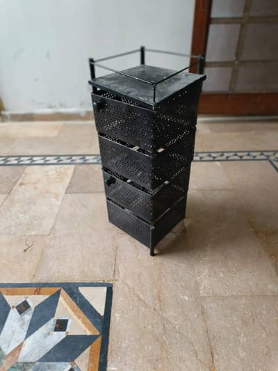 A small multi-layer metal storage organizer or drawer cabinet.