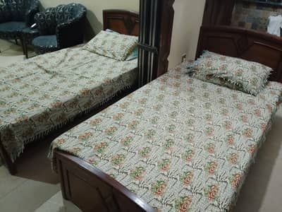 Two Single wooden Beds.