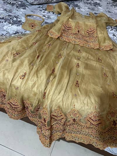 Golden lehnga for walima. . Free pouch