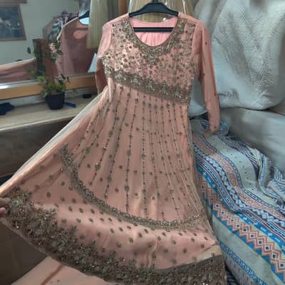 Heavy Peach Frock, paired with net duppatta and silk trouser.