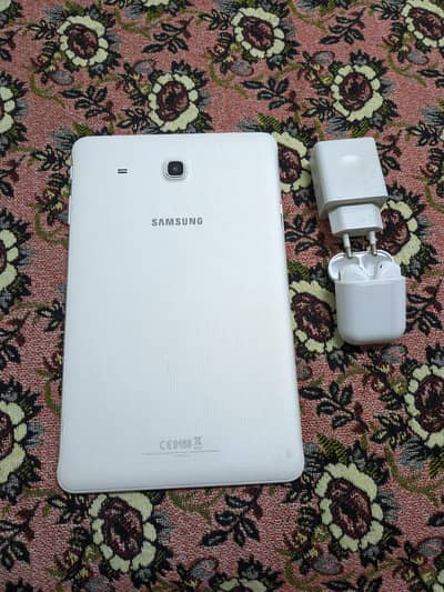 Samsung Galaxy tab E with earbuds and charger