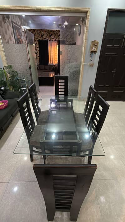 Wooden dining table with glass top and 6 wooden chairs