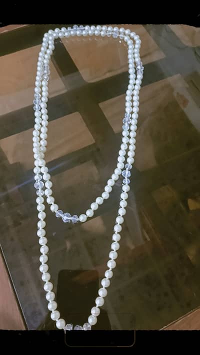 Handmade pearls and crystal necklace of white colour .