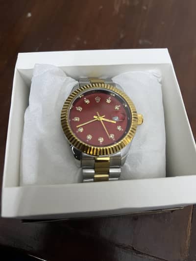 Brand new golden and maroon watch.