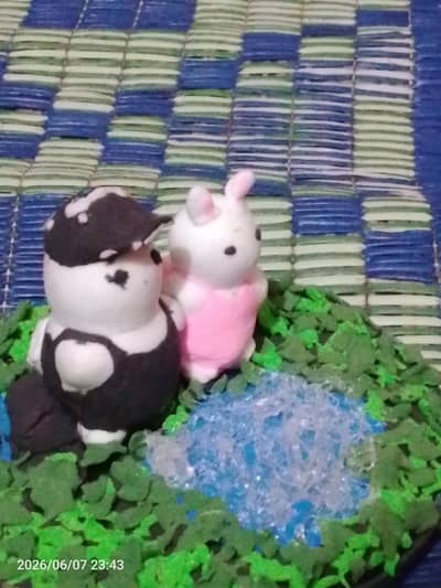 2 little bunnies sitting on a log sea the pond
