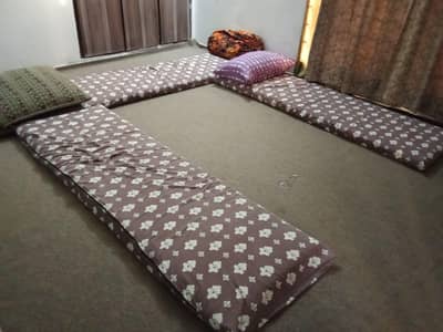 Room sitting setup include carpet, mattress, floor cushion and pillows