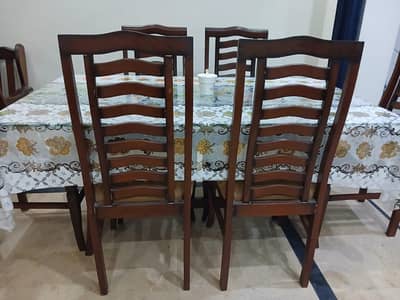 6 seater wooden dining table with glass top and cushion chairs
