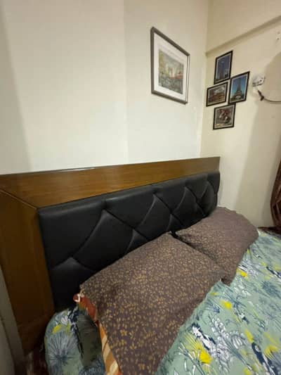 Modern bed made with wood frame with black leather headboard