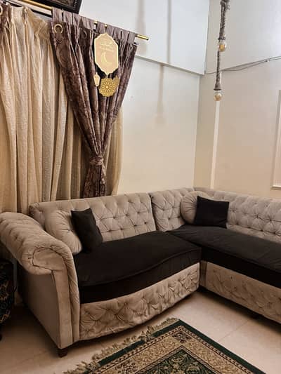 L shaped sofa with cream and black colour combination with 4 cushions