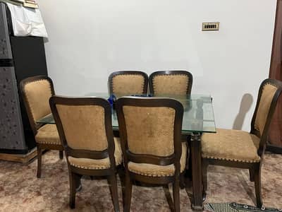 6 seater brown wooden dinning table with glass rack inside it