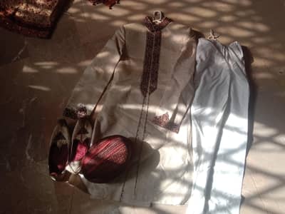 The groom dress with a trouser and a shoes as well with the grooms cap