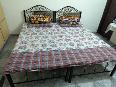 Pair of single beds with mattresses
