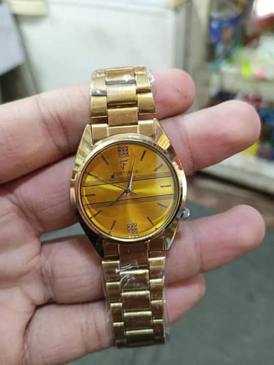 Gold analog wristwatch with striped dail & F logo