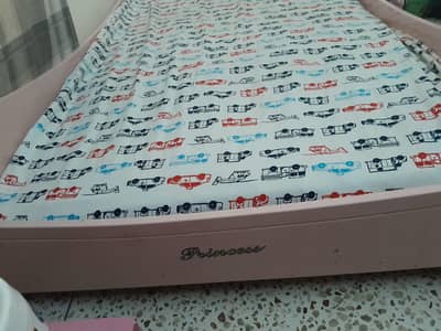 pink bed without mattress and toys