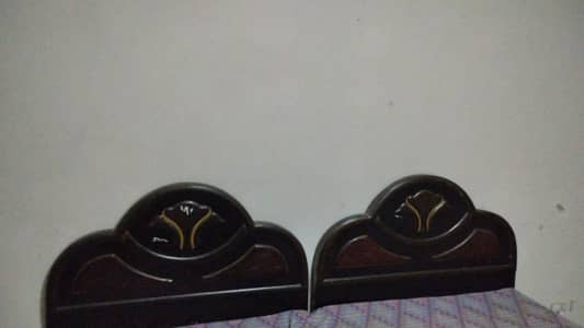 two black wooden beds with a dressing table and a sofa