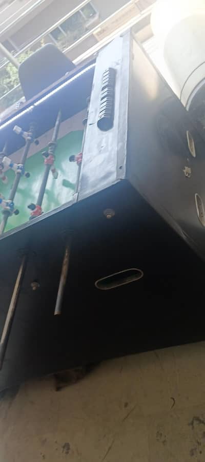 foosball table covered with glass and led lights on edges.