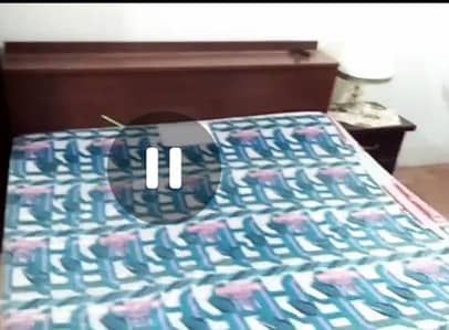 Queen bed with mattress and side table in surjani
