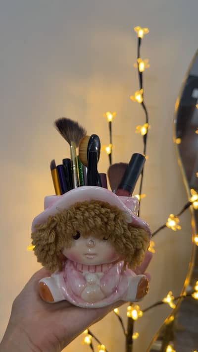 Makeup brushes stand in doll face