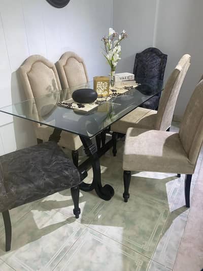 Luxury 6-seater glass top dining table set with upholstered chairs.