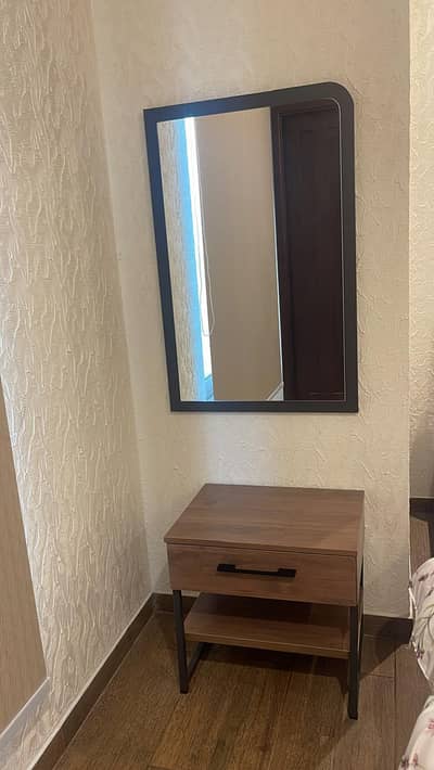 Bed with mattress, side table and looking mirror.