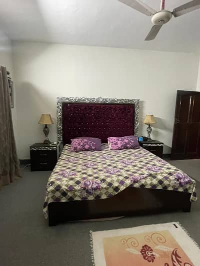 King size bed with side tables, dressing table, and sofa chairs