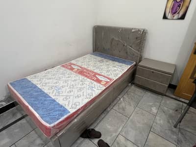 Single bed with mattress and side table