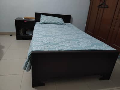 wooden newly polished bed set with side table.