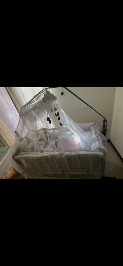 Baby cot with premium bedding, protective net and cot accessories.