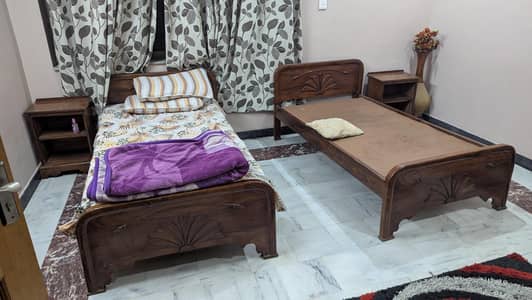 two single beds with side tables and two forms