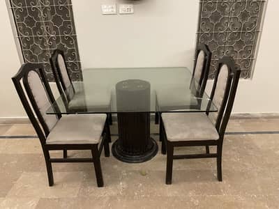 4-Seater Glass Dining Table with cushioned wooden chairs