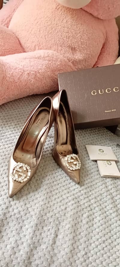 Gucci bronze metallic leather pumps featuring a crystal logo
