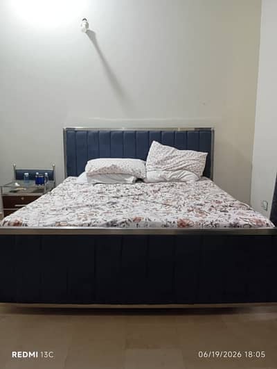 Queen sized metallic bed with a side table
