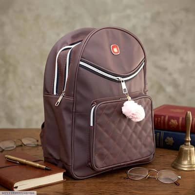 Brown leather girls school back pack with pom pom