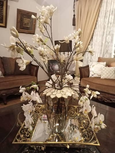 golden glass vase with acrylic flower petals on top.