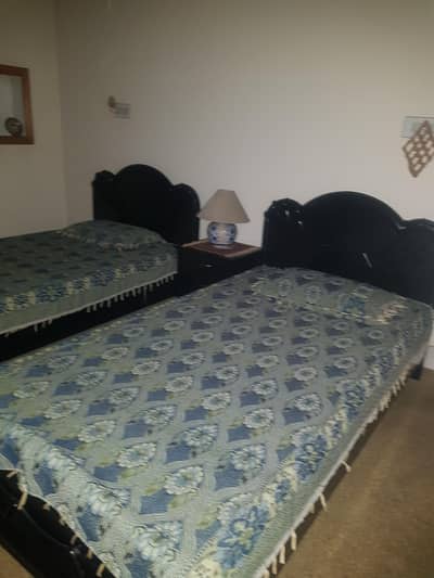 pair of single beds with table made from Lasani
