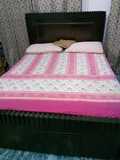 Queen size bed with spring mattress.