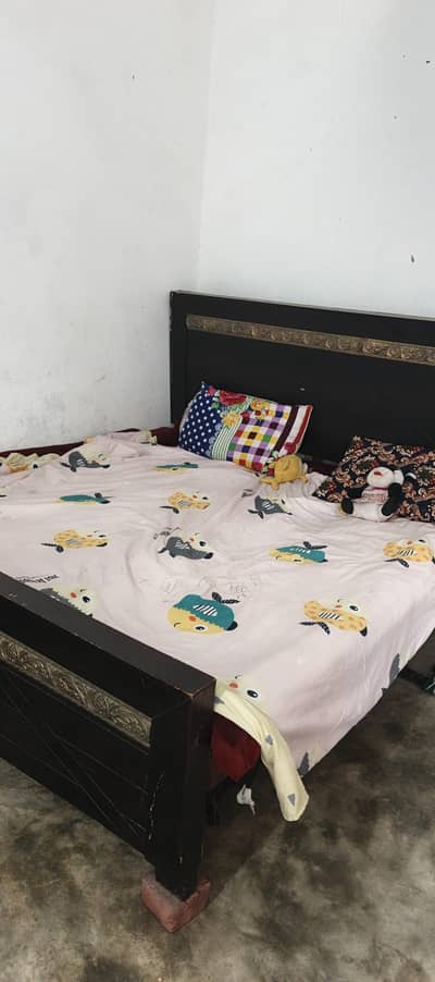 There is an empty bed, no side table and no mattress.