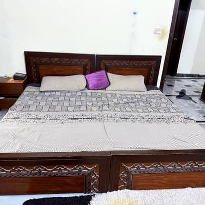 two single beds with side tables without mattress