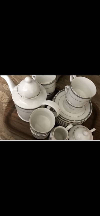 A white n grey coloured tea set to be sold