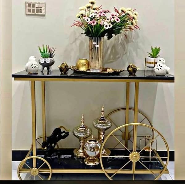 Designer Entryway Console with Black wooden Marble Texture Top, Gold Metal Structure and Unique Rolling Cart Inspired Decorative Frame