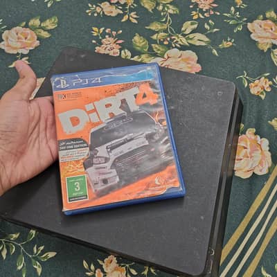 PlayStation 4 with two controllers and CD of dirt 4