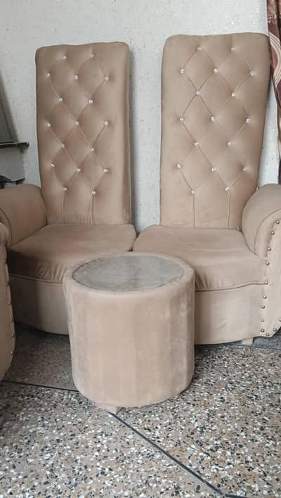two coefficias with table three 3 puffy seats