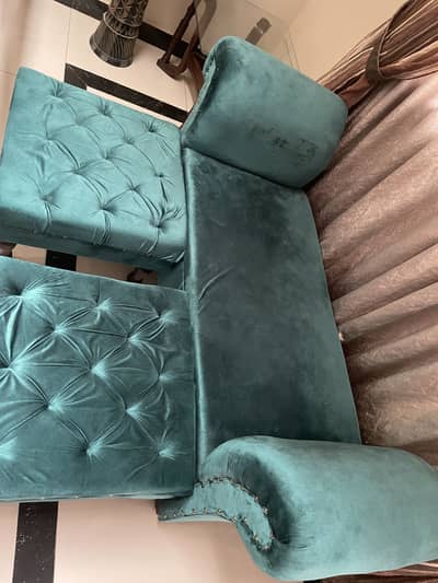 Two seater sofa with a set of puffy and coffee table